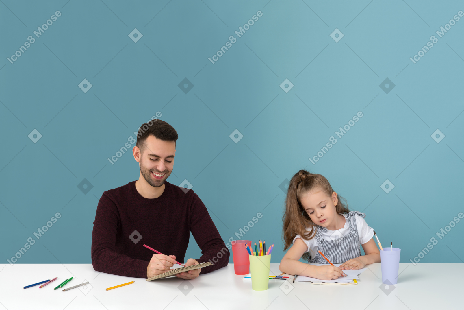 Dad and daughter are trying their best at drawing