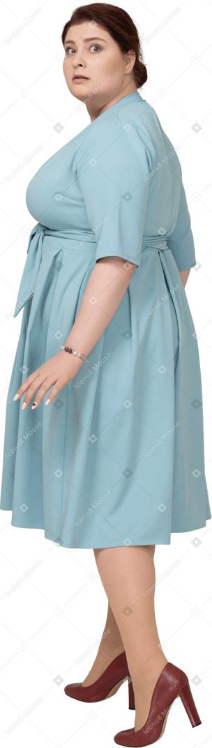 Vista laterale di una donna spaventata in abito blu