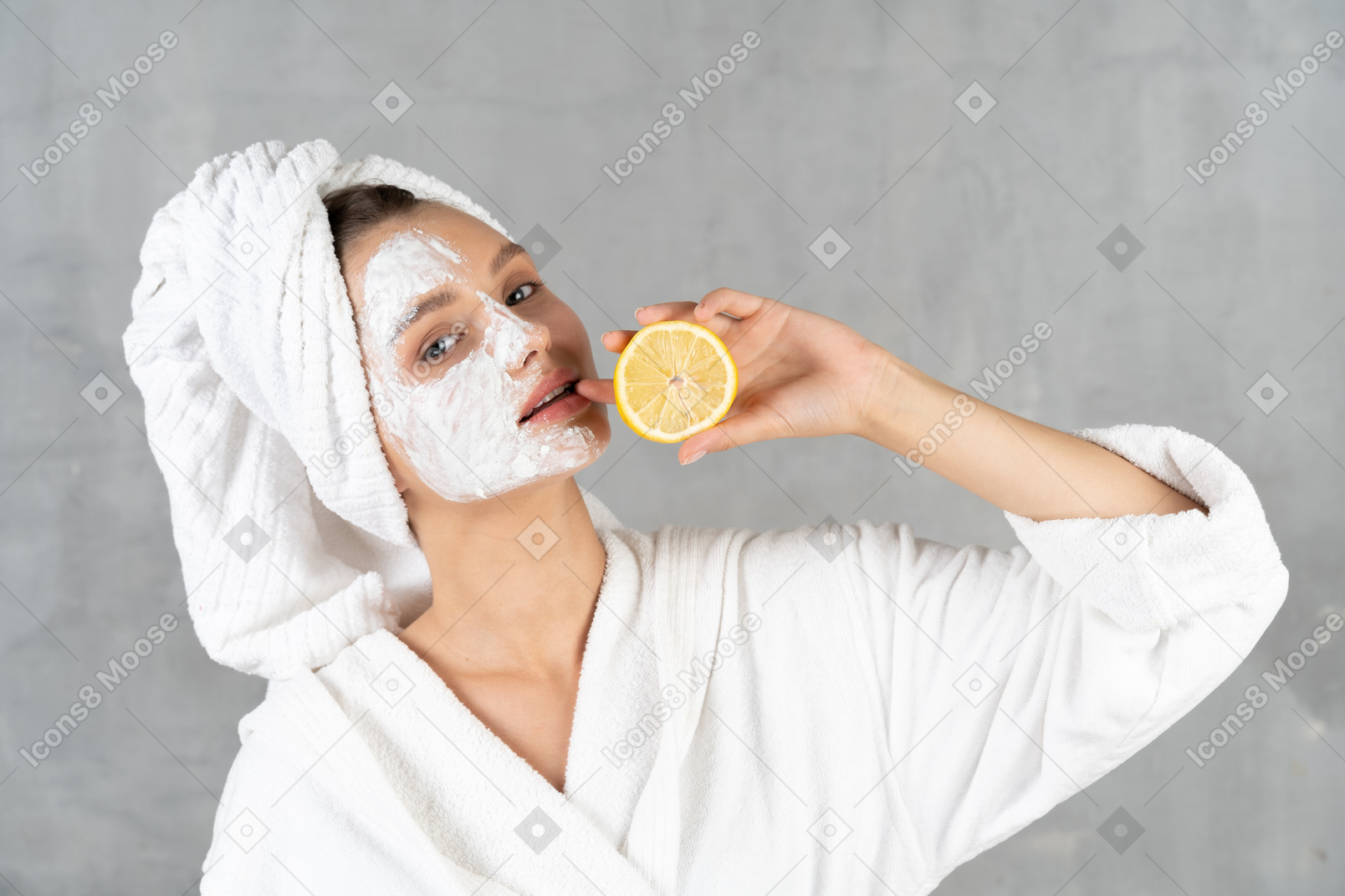 一个穿着浴袍的女人拿着柠檬的特写