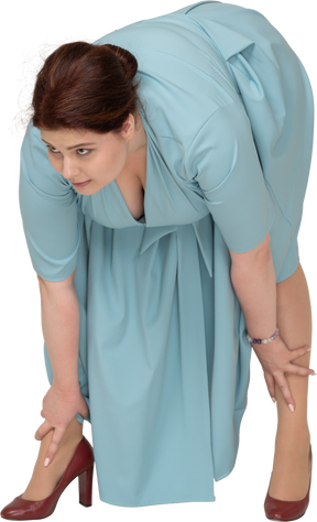 Front view of a woman in blue dress bending down