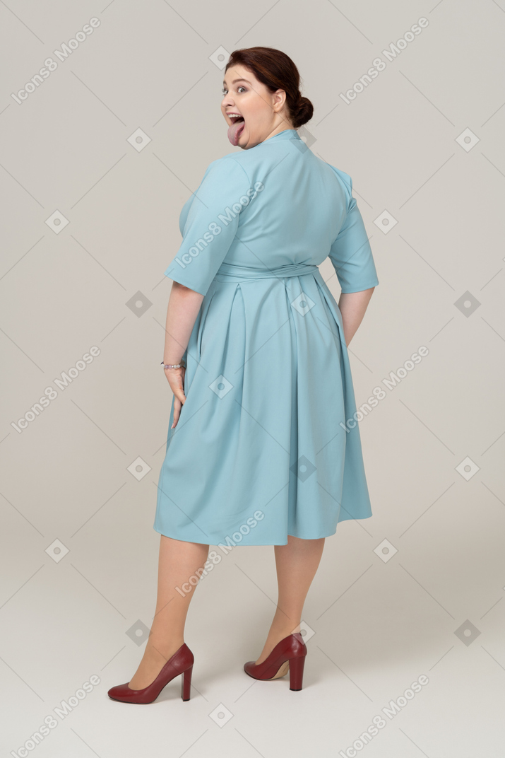 一个穿蓝色裙子的女人做鬼脸的后视图