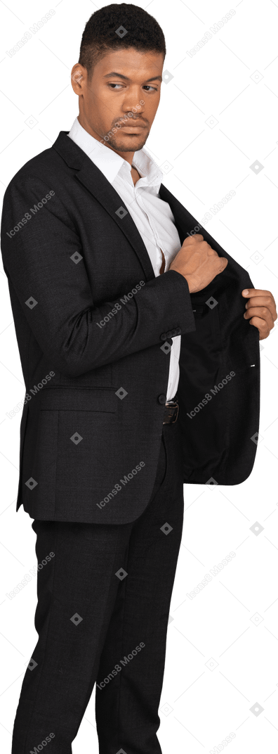 一个穿着黑色西装的年轻人在口袋里放东西的侧视图