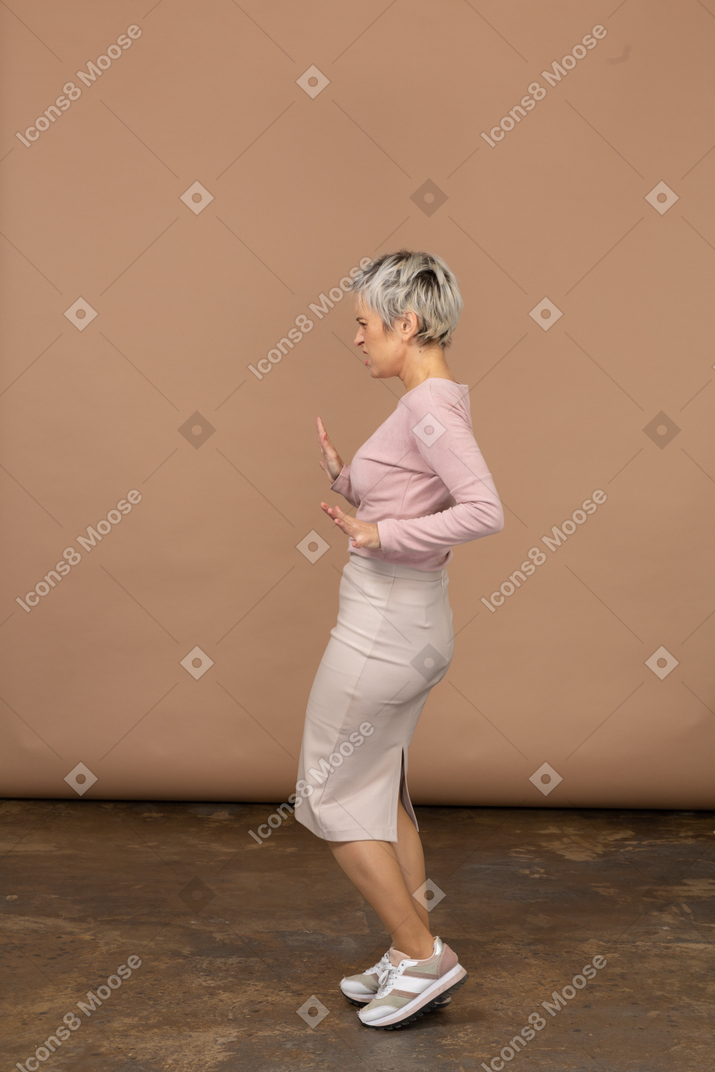 Side view of an emotional woman in casual clothes showing stop gesture