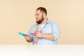 Big man holding hair brush and barbie doll