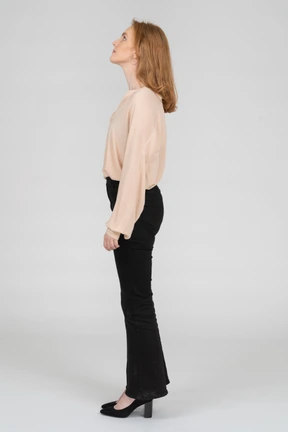 Side view of young woman standing and looking up