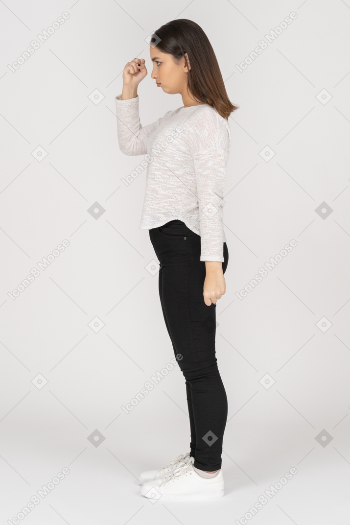 Side view of a mad young indian female in casual clothing clenching fist