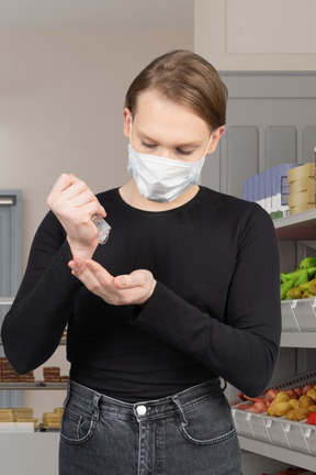 Homme utilisant un désinfectant pour les mains dans un magasin