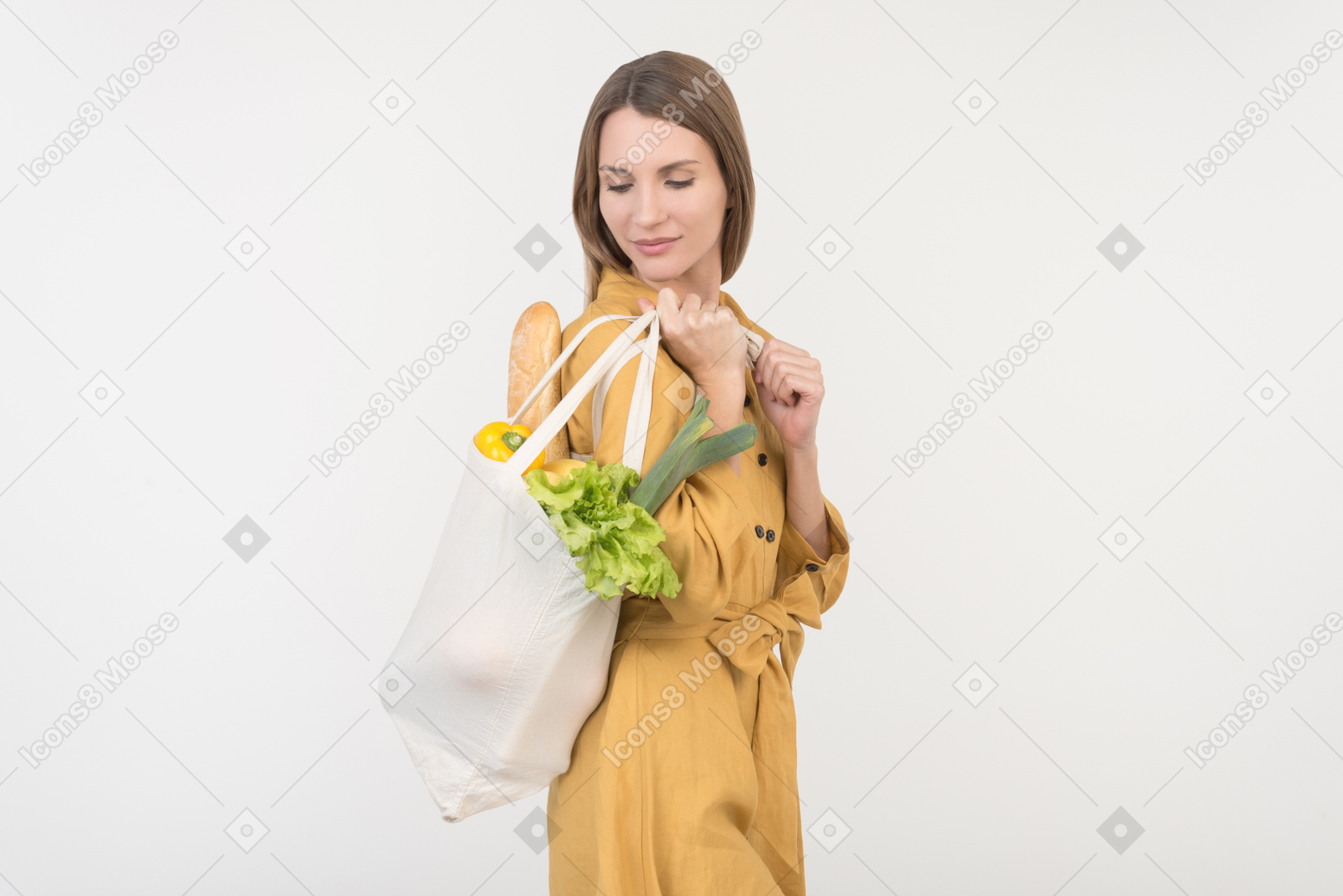 Young woman holding reusable shopping bag with vegetables