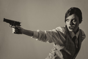 Desperate woman aiming a gun in the dark