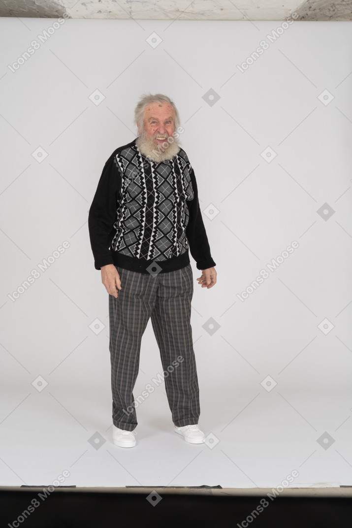 Vue de face d'un vieil homme souriant debout avec les bras sur les côtés