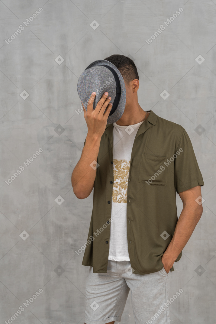 帽子で顔を覆う男性