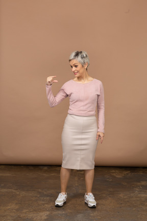 Vista frontal de una mujer en ropa casual que muestra el pequeño tamaño de algo