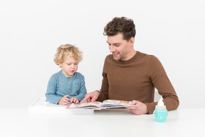 Padre e figlio che leggono un libro illustrato