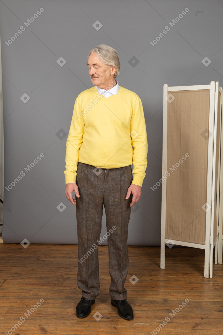 Front view of an old man in a yellow pullover turning his head