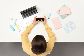 Um trabalhador de escritório feminino segurando o telefone móvel