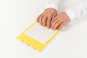 Cropped photo of hands of a man reading braille