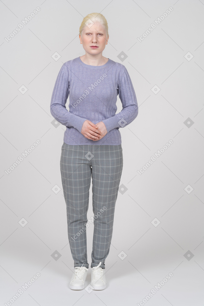 Serious young woman in casual clothes looking at camera