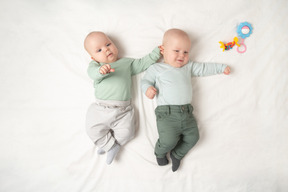 Babies twins lying on the back next to each other