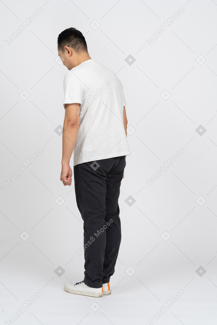 Vue latérale d'un homme en vêtements décontractés regardant vers le bas