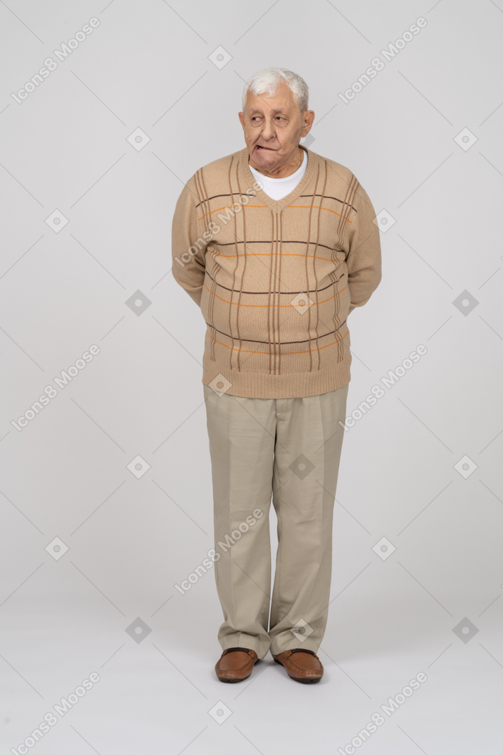 Vorderansicht eines alten mannes in freizeitkleidung, der gesichter macht