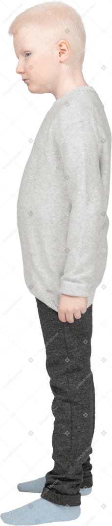 Vue latérale d'un enfant garçon dans des vêtements décontractés à côté