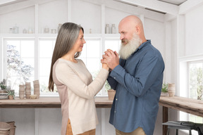 Elderly couple holding hands in the kitchen