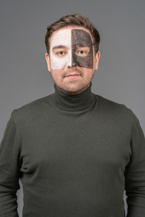 Front view of a male football fan with a black & white face art