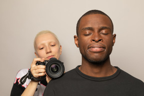 Donna con una macchina fotografica che riprende un uomo