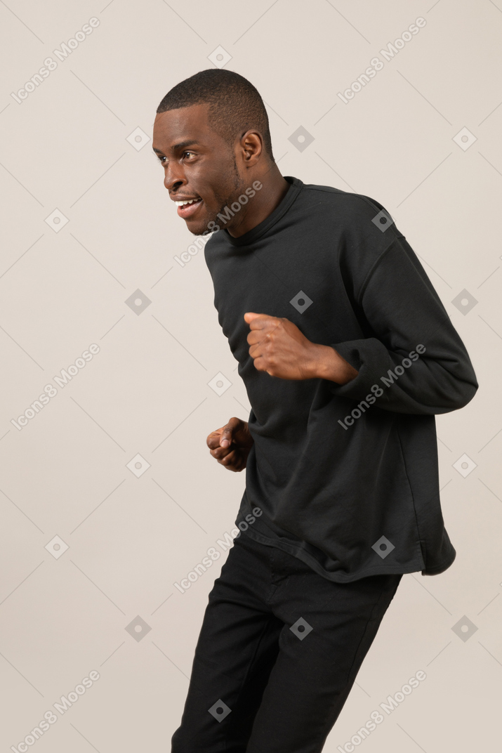 Three quarter view of happy young man running