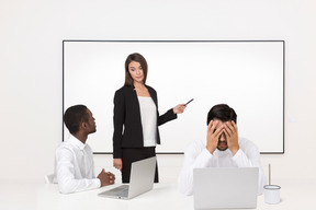 A group of business people sitting in front of a whiteboard