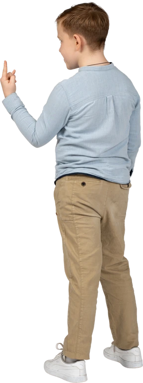 Rear view of a boy making rock gesture