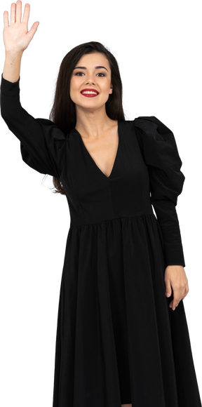 Front view of a smiling greeting young lady in a black dress