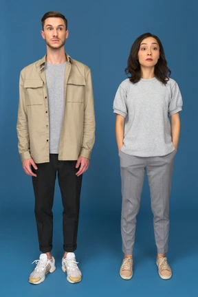 Surprised man and woman standing with raised eyebrows