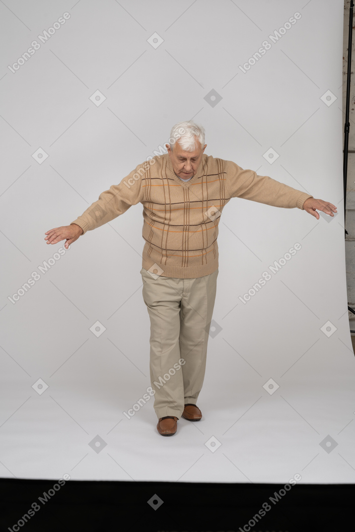 Вид спереди на старика в повседневной одежде, идущего вперед с распростертыми руками