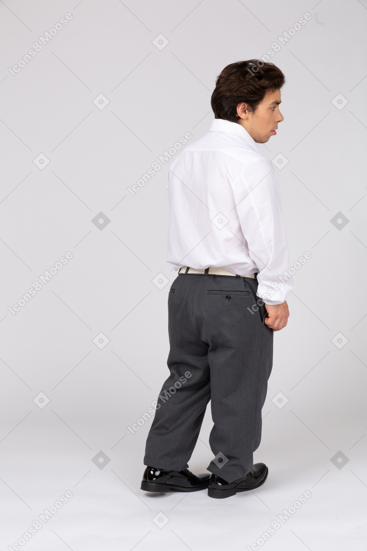 Young man in business casual clothes standing back to camera