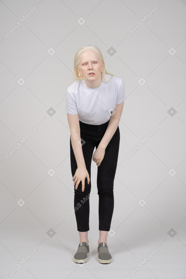 Jeune femme se penchant en avant et saisissant son genou