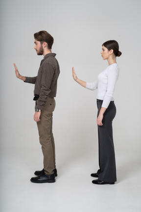 Side view of a young couple in office clothing outstretching hand