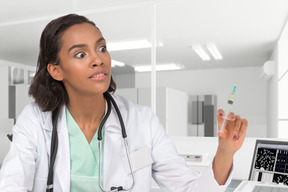 Shocked female doctor holding a syringe