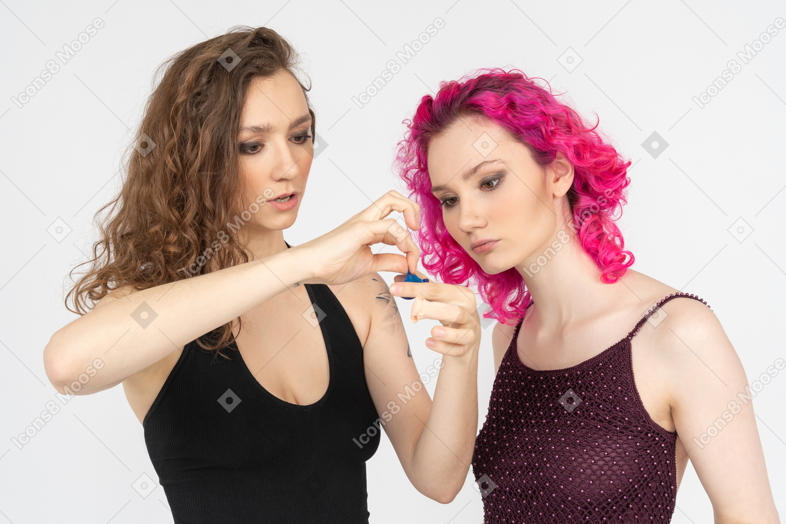 Elder sister teaching younger one to use condoms