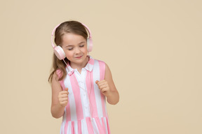 可爱的小女孩在耳机听音乐