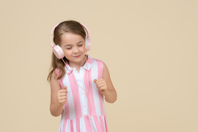 Mignonne petite fille au casque écoutant de la musique