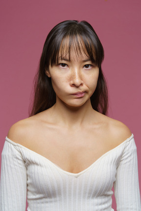 Vue de face d'une femme d'âge moyen regardant la caméra et grimaçant