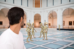 Man looking at a group of aliens in a museum