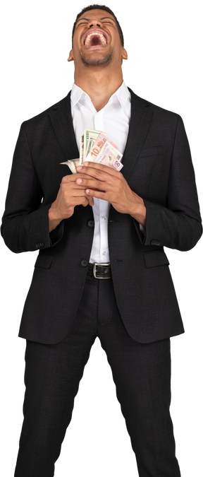 Front view of a young man in black suit holding banknotes