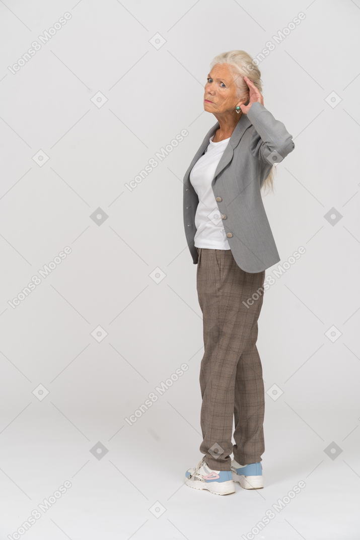 Side view of an old lady in suit listening attentively
