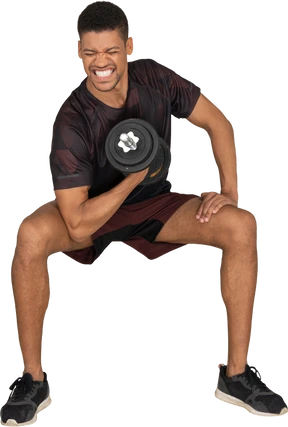 Young man in sports clothes lifting weigths