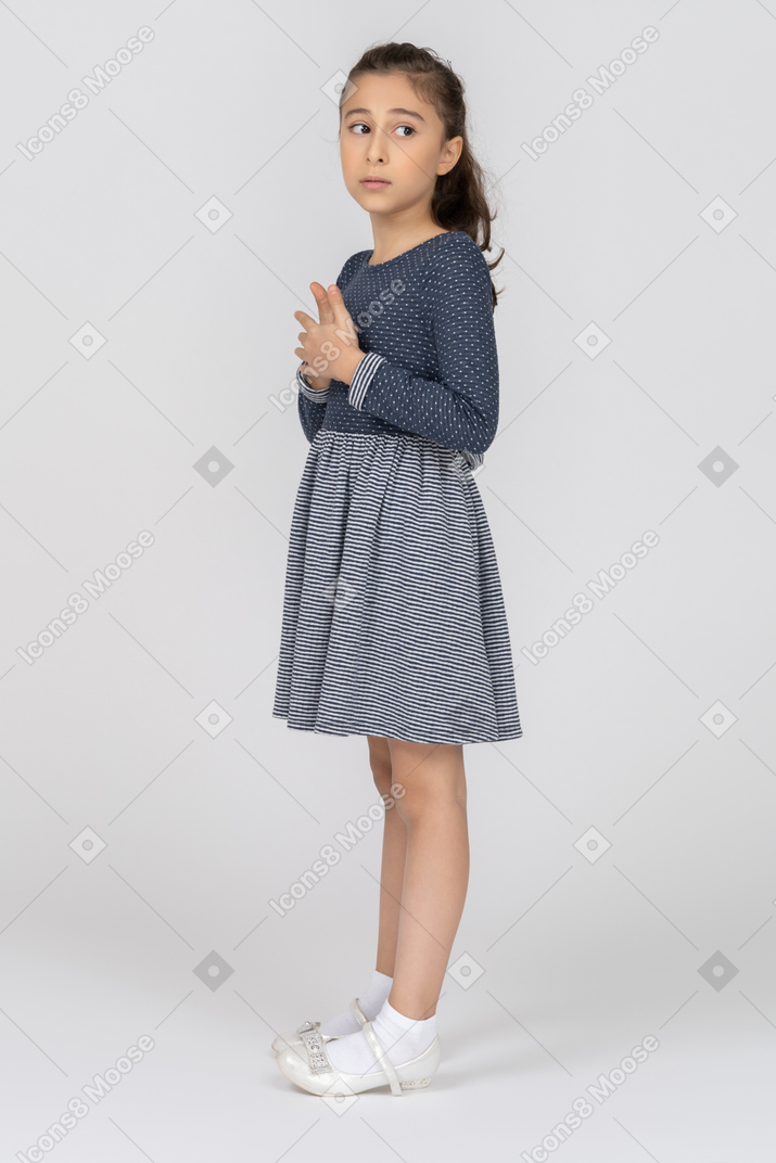 Vista lateral de una niña mirando por encima del hombro hacia un lado
