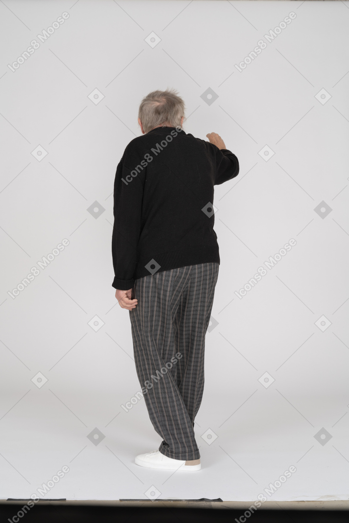 Back view of old man gesturing with hand