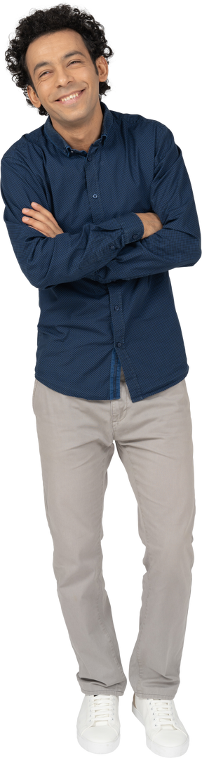 Vista frontal de um homem com roupas casuais posando com os braços cruzados