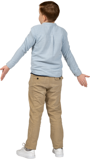 Vista posteriore di un ragazzo in piedi con le braccia tese